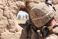 U.S. Marine Corps Capt. Justin Poust with a Police Advisory Team (PAT) with India Company, 3nd Battalion, 8th Marine Regiment, Regimental Combat Team 5, looks through his rifle combat optic during a routine logistical check with Afghan Uniform Police in Marjah District, Helmand province, Afghanistan, July 1, 2012.