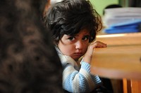 A young Afghan girl sits on her mother's lap during a graduation ceremony for her mother and other graduates of a photojournalism training course in Farah City, Feb. 17. Provincial Reconstruction Team (PRT) Farah attended the graduation ceremony for a two-week photojournalism course for Farahi journalists to recognize the achievements of the graduates and to further develop relationships built during the program.