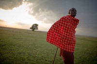 Josphat Mako, Maasai guide and companion to author and travel writer Stuart Butler stands as the sun begins to set over the Mara North Conservancy adjacent to Kenya's world famous Maasai Mara National Reserve