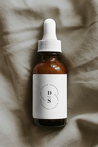 Amber dropper bottle template on gray fabric background