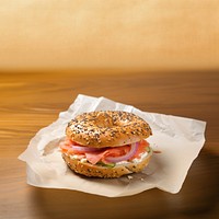 Close-up of Lox Bagel with onions on paper sheet.  