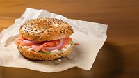 Close-up of Lox Bagel with onions on paper sheet.  