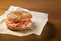 Close-up of Lox Bagel with onions on paper sheet.  