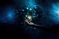 close-up remix photo of hand holding a light bulb with the earth inside.  