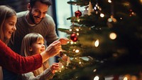 closeup photo of family decorating a Christmas tree.  