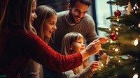 closeup photo of family decorating a Christmas tree.  