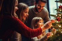 closeup photo of family decorating a Christmas tree.  