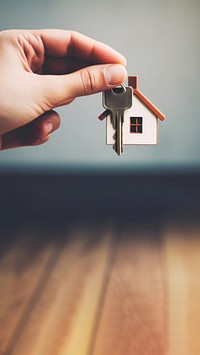 close up photo of black hand holding house key.  