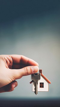 close up photo of black hand holding house key.  