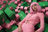 a woman lying on top of boxes of beeps in green, in the style of candycore, pink, berrypunk.  