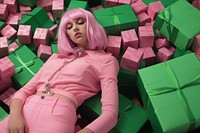 a woman lying on top of boxes of beeps in green, in the style of candycore, pink, berrypunk.  