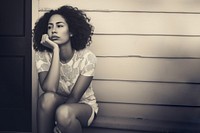 Authentic photo of mixed race woman is sitting and contemplating something.  