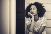 Authentic photo of mixed race woman is sitting and contemplating something.  