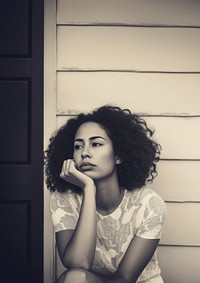 Authentic photo of mixed race woman is sitting and contemplating something.  