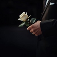 photo of hand in suit put white rose on a funeral casker. AI generated Image by rawpixel. 