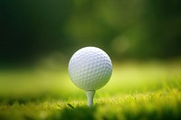 photo of a close up the golf ball on tee pegs ready to play, light green, natural light. 