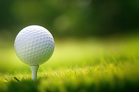 photo of a close up the golf ball on tee pegs ready to play, light green, natural light. 