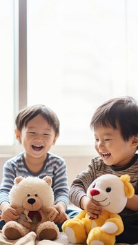 photo of two boys playing with toy stuff animals dolls together. 