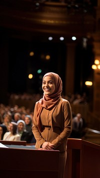 Young Muslim woman speaker on professional stage.  