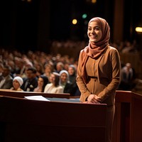 Young Muslim woman speaker on professional stage.  