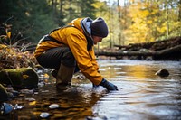 Ecologist taking water sample outdoors nature stream. 