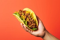 Mexican taco beef holding yellow food. 