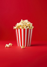 a photograph of a striped box with popcorn isolated on solid color background.  