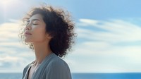 photo of woman praying with bluesky on the sea with blurred vision.  