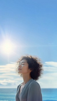 photo of woman praying with bluesky on the sea with blurred vision.  