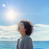 photo of woman praying with bluesky on the sea with blurred vision.  