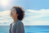 photo of woman praying with bluesky on the sea with blurred vision.  