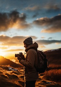 front-left view Photo of a man holding camera, taking picture in the wild in a chilly day. 