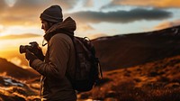 front-left view Photo of a man holding camera, taking picture in the wild in a chilly day. 