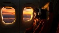 photo of an african woman looking through the window on an airplane. 