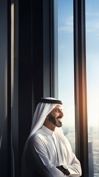 Photo of an Arabic businessman looking out of a window. 