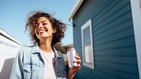 Portrait photo of a happy woman holding aluminum can looking at out side on minimal home. 