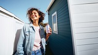 Portrait photo of a happy woman holding aluminum can looking at out side on minimal home. 