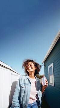 Portrait photo of a happy woman holding aluminum can looking at out side on minimal home. 