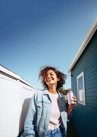 Portrait photo of a happy woman holding aluminum can looking at out side on minimal home. 