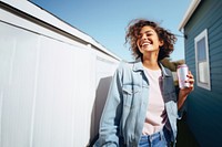 Portrait photo of a happy woman holding aluminum can looking at out side on minimal home. 