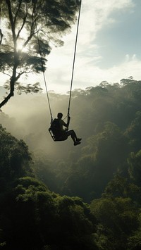 Photo of a man playing zipline through jungle