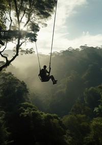 Photo of a man playing zipline through jungle. 