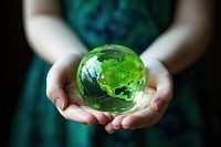 Girl holding a green fluid earth sphere planet globe. 