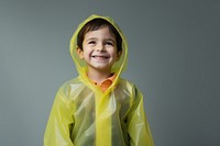 Kid wearing a raincoat standing smiling sweatshirt. 