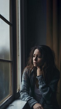 image of sad person looking out window. 