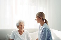 minimal, photo of staff caregiver talking to senior woman in hospital. 