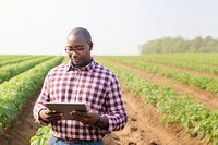 Photo of Black American farmer with digital tablet in potato field. AI generated Image by rawpixel.