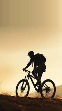 photo side view sillhuette of man riding a bicycle bike uphill with natural light. 