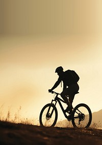 photo side view sillhuette of man riding a bicycle bike uphill with natural light. 