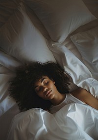 photos of a black woman lying on the side sleeping in white bed. 